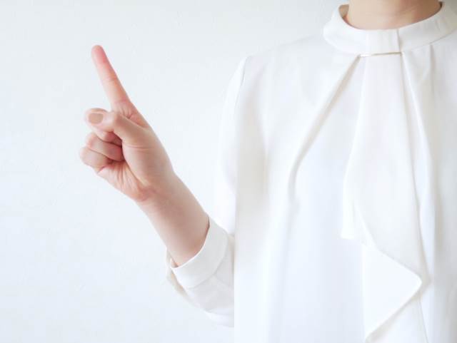 人差し指を立てる女性